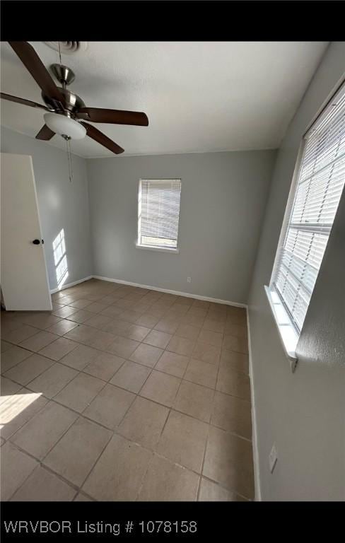 unfurnished room with ceiling fan and light tile patterned floors