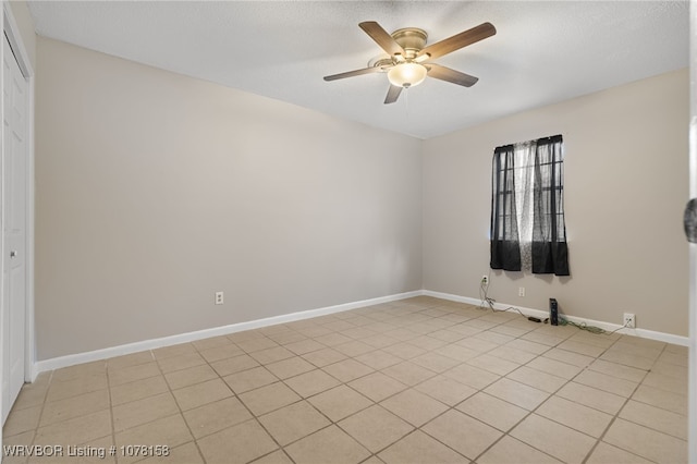 tiled spare room with ceiling fan