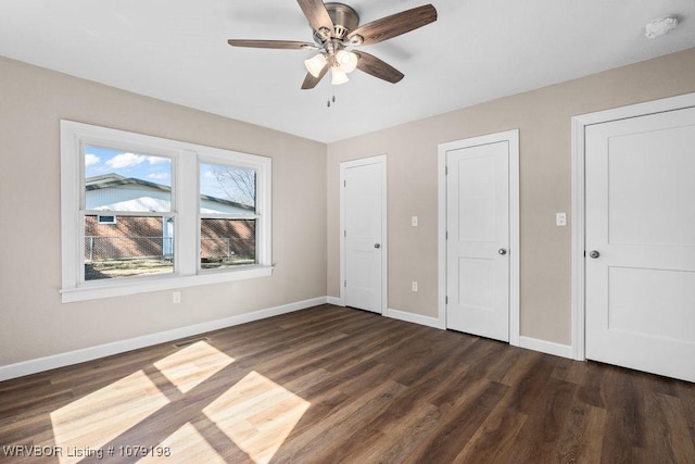 unfurnished bedroom with dark wood-style flooring and baseboards