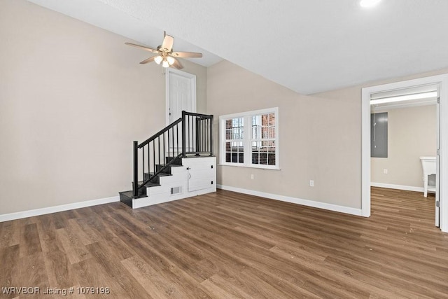 unfurnished living room featuring stairway, baseboards, and wood finished floors