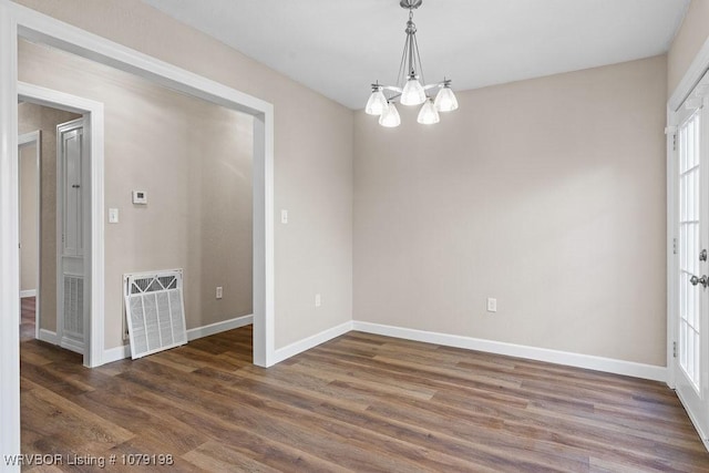 unfurnished room with baseboards, visible vents, and dark wood finished floors