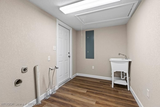 laundry area with attic access, dark wood-type flooring, laundry area, electric panel, and baseboards