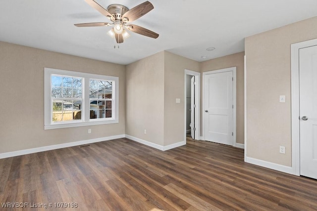 unfurnished room featuring dark wood-style floors, baseboards, and a ceiling fan