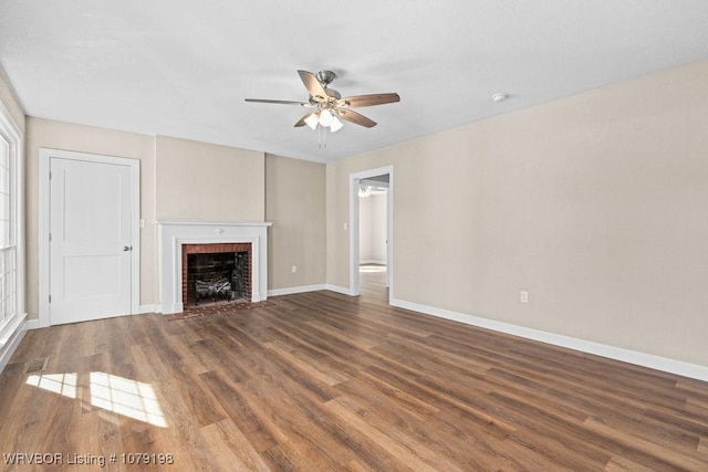 unfurnished living room with dark wood-style flooring, a fireplace, baseboards, and ceiling fan