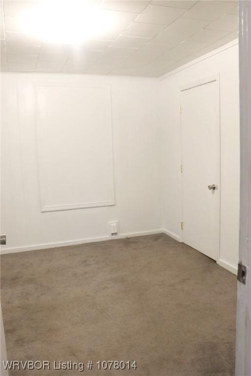 unfurnished room featuring dark carpet