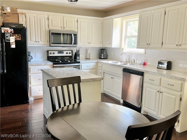 kitchen with sink, dark hardwood / wood-style flooring, decorative backsplash, white cabinets, and appliances with stainless steel finishes