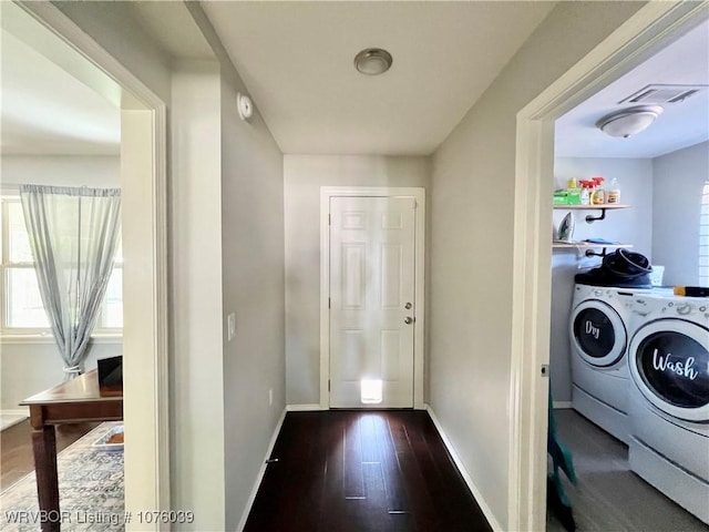 clothes washing area with dark hardwood / wood-style floors and separate washer and dryer