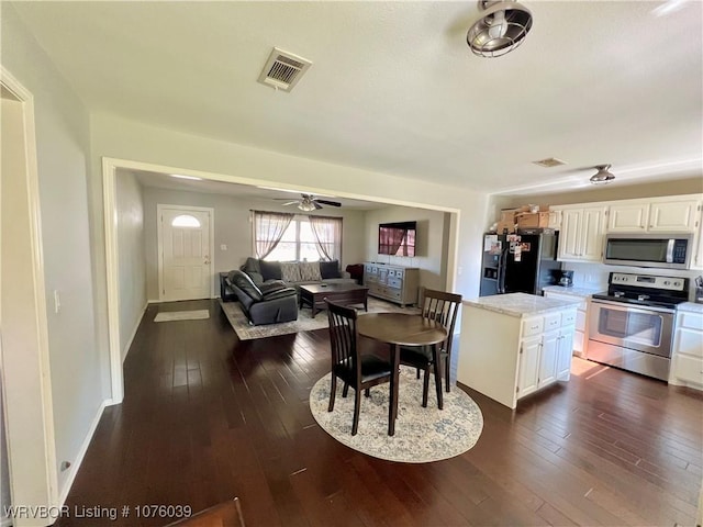 kitchen featuring white cabinets, ceiling fan, stainless steel appliances, and dark wood-type flooring