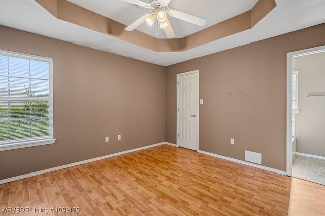 3707 Princeton Ct, Van Buren, AR 72956 - unfurnished room featuring light wood-style flooring, a raised ceiling, and a ceiling fan