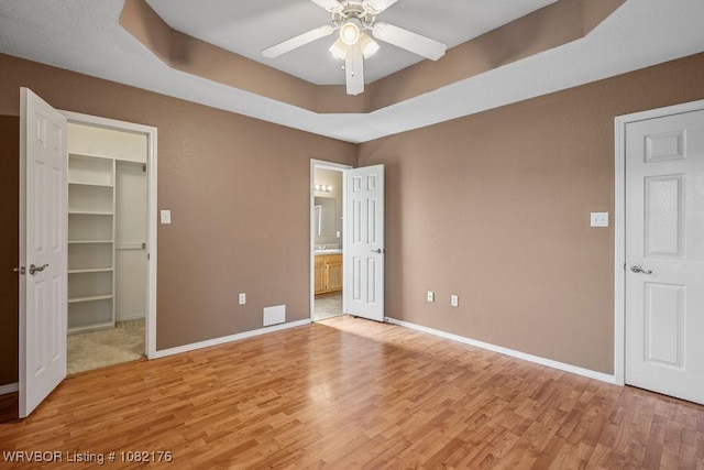 3707 Princeton Ct, Van Buren, AR 72956 - unfurnished bedroom featuring light wood-style flooring, a spacious closet, ensuite bath, a closet, and a ceiling fan