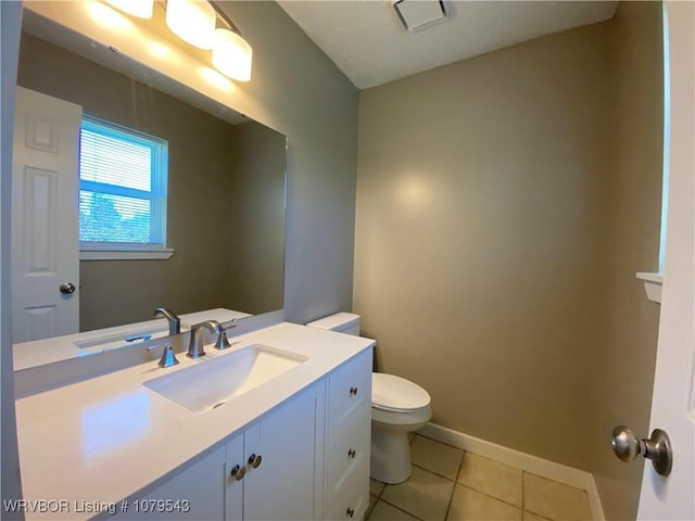 bathroom with tile patterned flooring, toilet, vanity, and baseboards