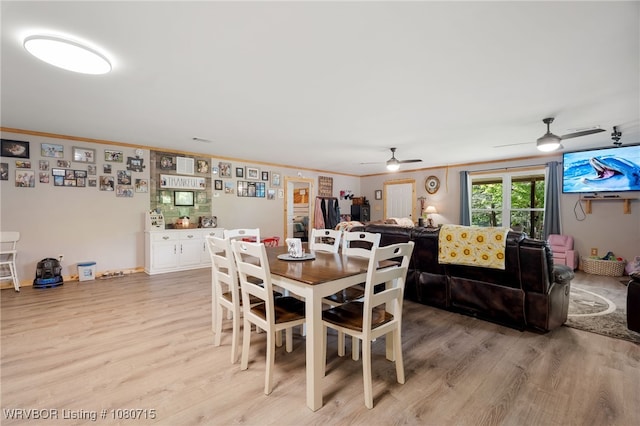dining area featuring crown molding, a ceiling fan, and light wood finished floors