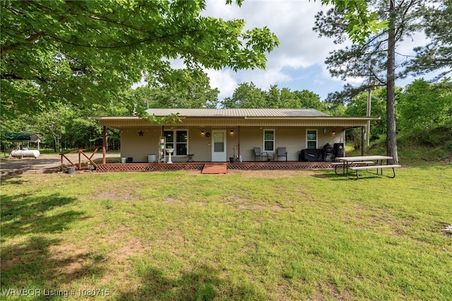 back of house featuring covered porch and a lawn