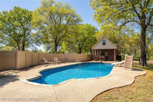 view of pool featuring a patio area, a water slide, fence, an outdoor structure, and a fenced in pool