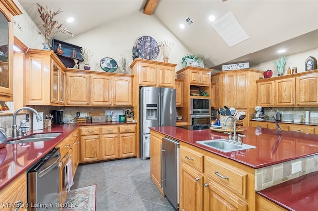 kitchen with appliances with stainless steel finishes, decorative backsplash, a sink, and beamed ceiling