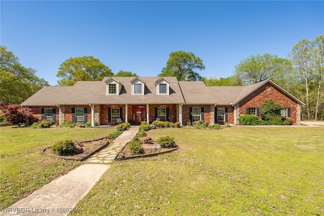 cape cod home featuring brick siding and a front lawn