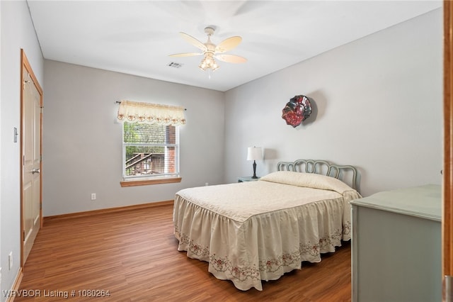 bedroom with visible vents, baseboards, and wood finished floors