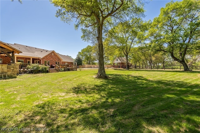 view of yard with a deck and fence