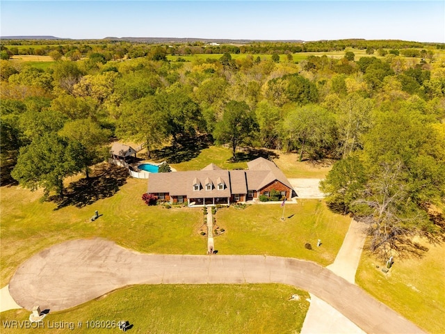 drone / aerial view featuring a wooded view