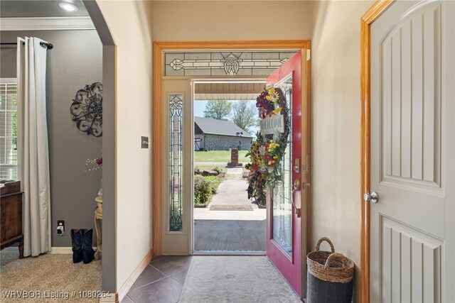 tiled entrance foyer with arched walkways and baseboards