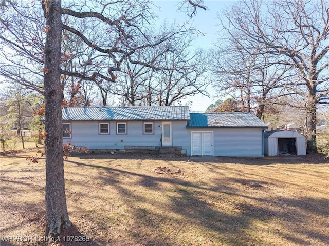 ranch-style home featuring an outbuilding and a front lawn