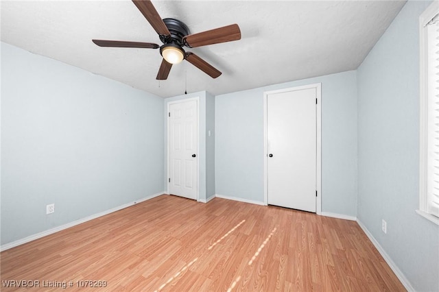 unfurnished bedroom with ceiling fan and light hardwood / wood-style floors