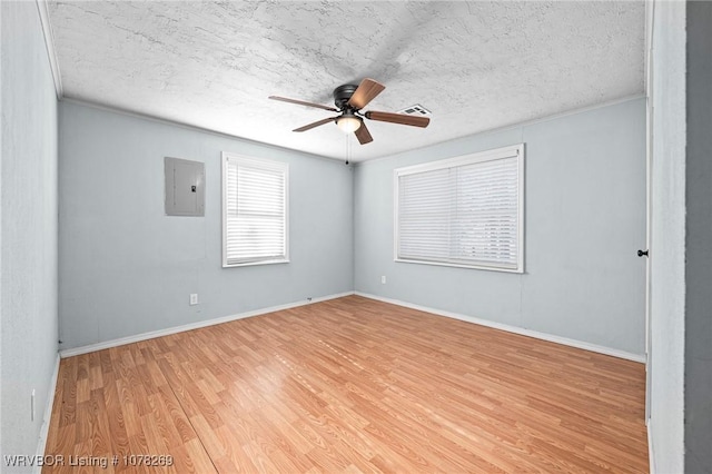 unfurnished room featuring ceiling fan, electric panel, hardwood / wood-style floors, and a textured ceiling