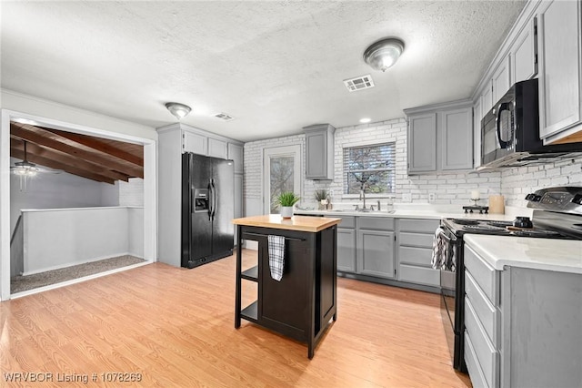 kitchen featuring gray cabinetry, sink, and black appliances