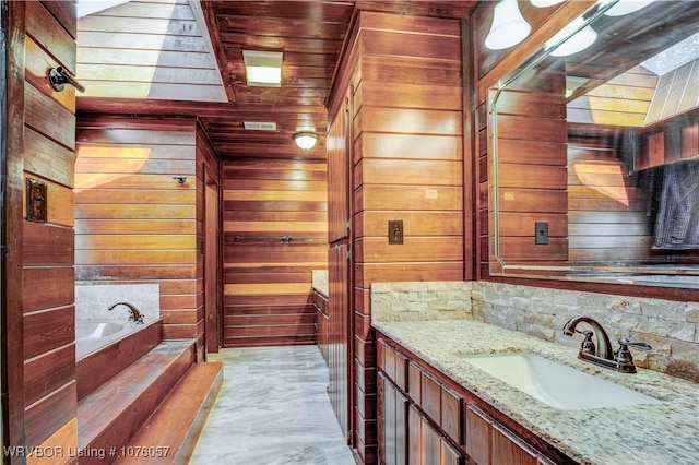 bathroom featuring vanity, wood walls, and a tub