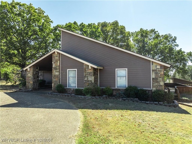 ranch-style home featuring a front lawn and a carport