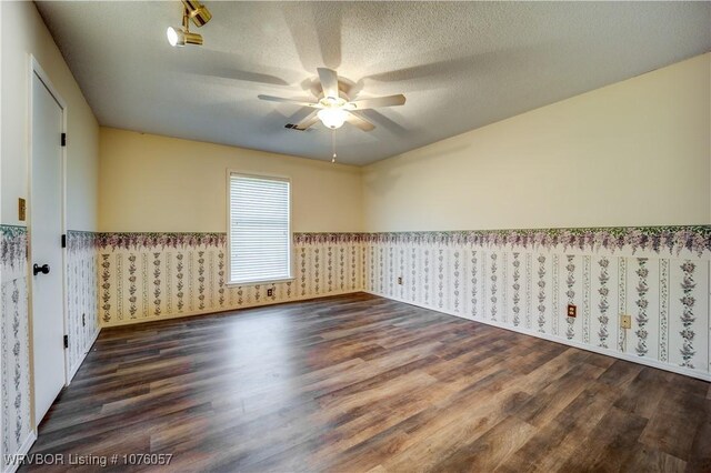 unfurnished room featuring ceiling fan, dark hardwood / wood-style floors, and a textured ceiling