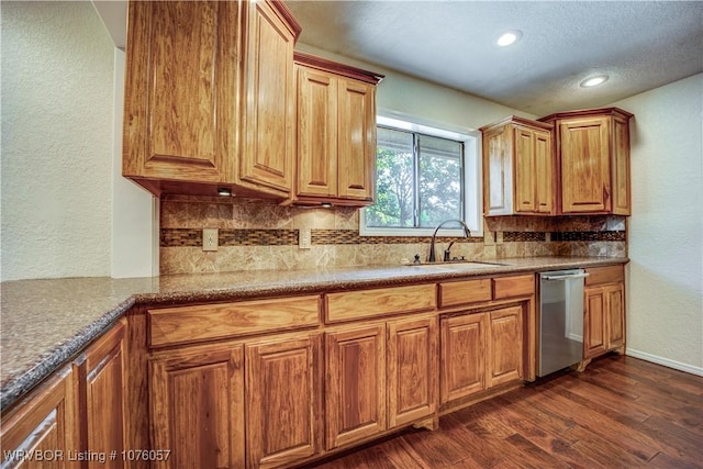 kitchen with dark hardwood / wood-style flooring, decorative backsplash, dishwasher, and sink