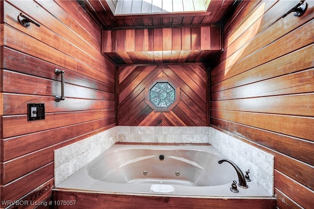 bathroom featuring a tub and wooden walls