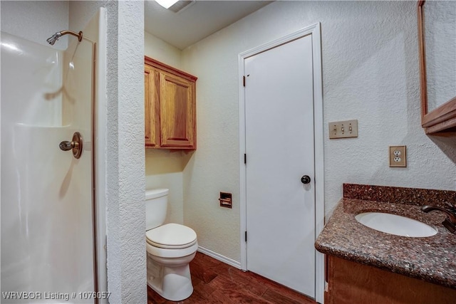 bathroom with vanity, hardwood / wood-style flooring, toilet, and walk in shower