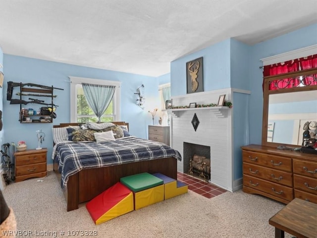 carpeted bedroom with a brick fireplace