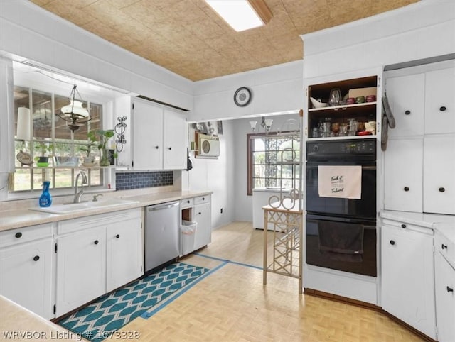 kitchen featuring stainless steel dishwasher, white cabinets, sink, and double oven