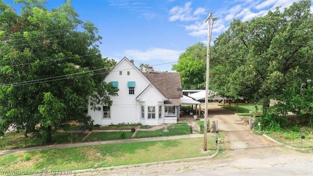 view of front of house featuring a carport and a front lawn