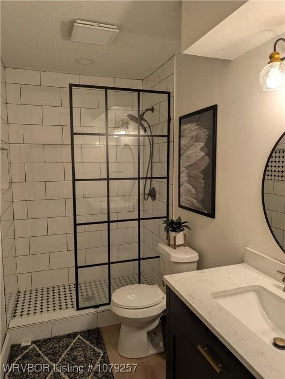 bathroom featuring visible vents, toilet, wood finished floors, vanity, and a shower stall