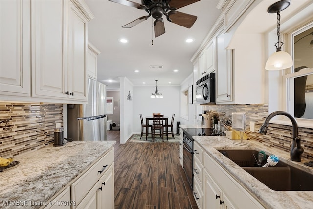 kitchen with crown molding, light stone countertops, dark wood finished floors, stainless steel appliances, and a sink