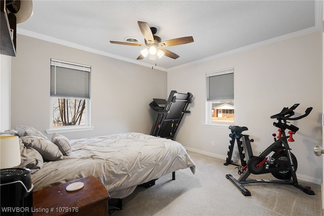 carpeted bedroom featuring crown molding, baseboards, and ceiling fan