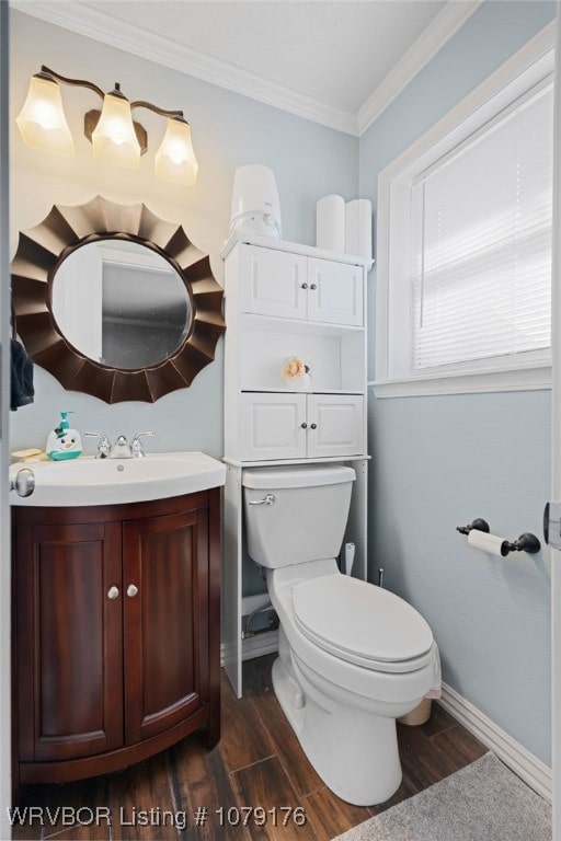 half bathroom featuring vanity, toilet, wood finished floors, and ornamental molding