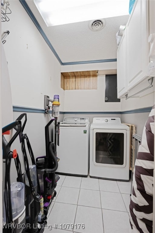 laundry room featuring visible vents, independent washer and dryer, a textured ceiling, cabinet space, and light tile patterned floors