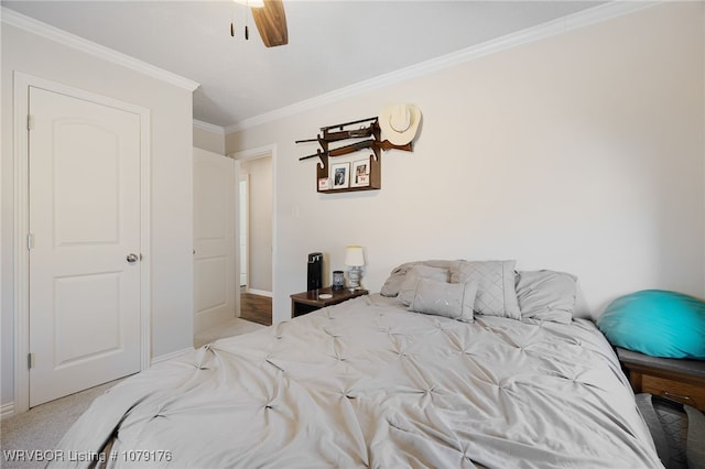 carpeted bedroom with ceiling fan, baseboards, and ornamental molding