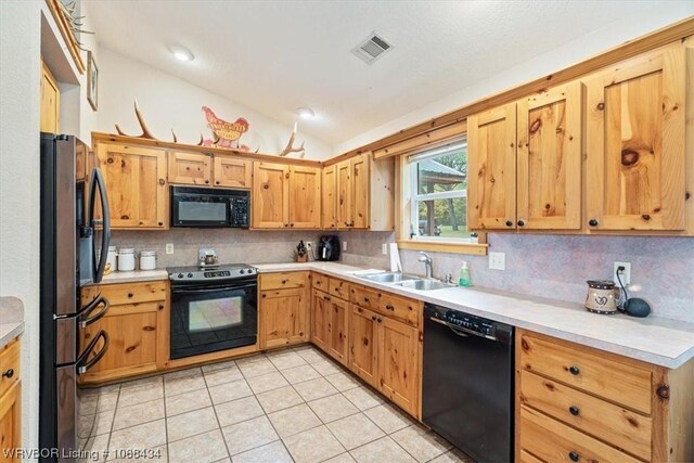 kitchen featuring sink, backsplash, lofted ceiling, and black appliances