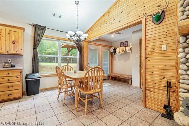 dining area with light tile patterned flooring, vaulted ceiling, and a notable chandelier