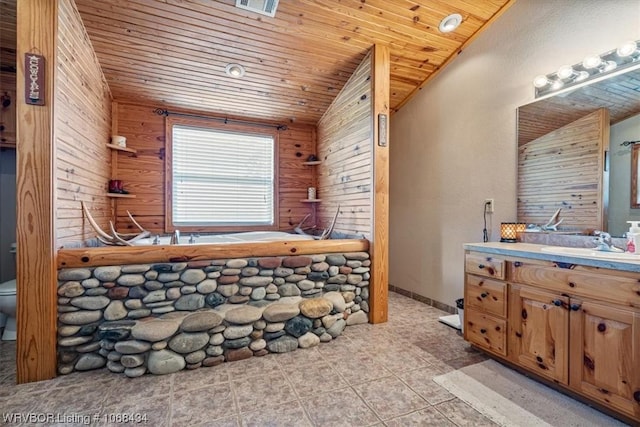 bathroom featuring vanity, wooden walls, wooden ceiling, toilet, and lofted ceiling