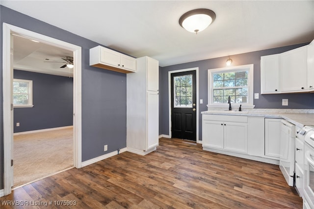 kitchen featuring ceiling fan, dark wood-type flooring, sink, dishwasher, and white cabinets