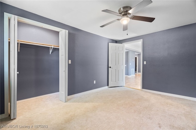 unfurnished bedroom featuring ceiling fan, a closet, and light colored carpet