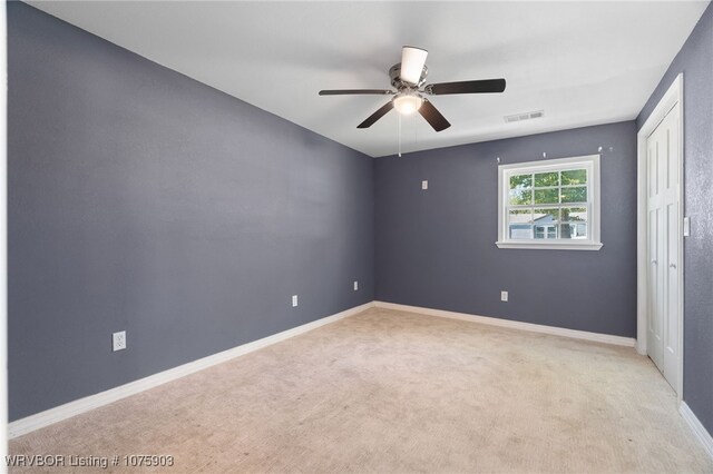 carpeted spare room featuring ceiling fan