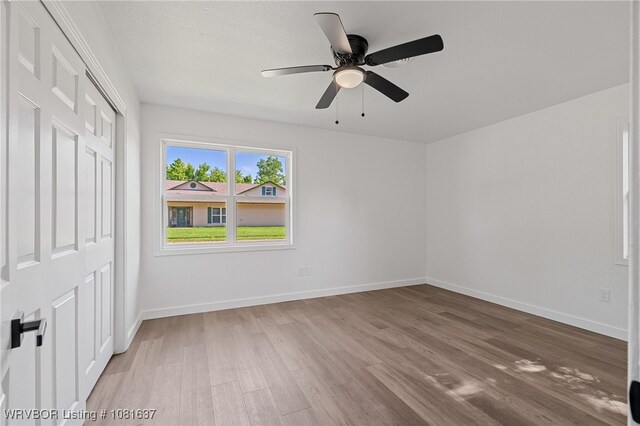 123 Oak St, Alma, AR 72921 - unfurnished bedroom featuring wood finished floors, a closet, and a ceiling fan